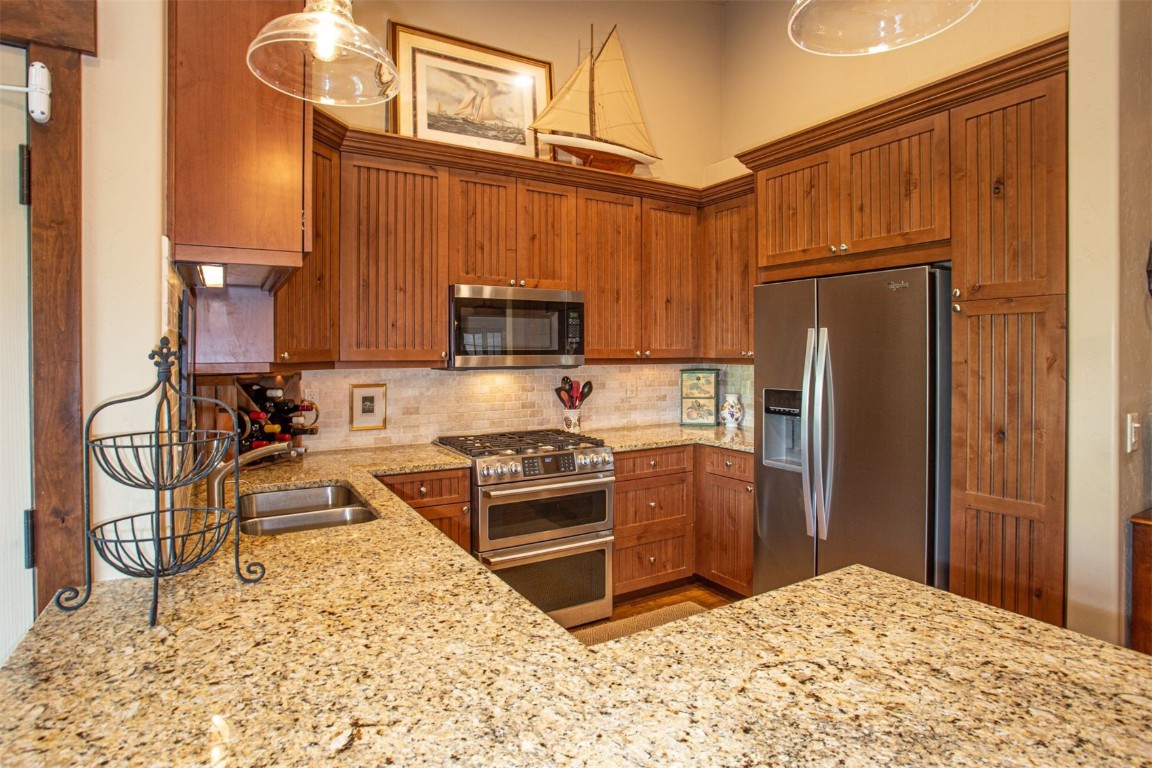 421 Rainbow Drive, Unit 5 Silverthorne, CO 80498 - Photo 16 of 36 a kitchen with stainless steel appliances granite countertop a stove a refrigerator and a sink