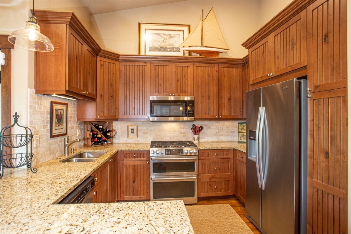 421 Rainbow Drive, Unit 5 Silverthorne, CO 80498 - Photo 17 of 36 a kitchen with granite countertop a refrigerator stove and microwave
