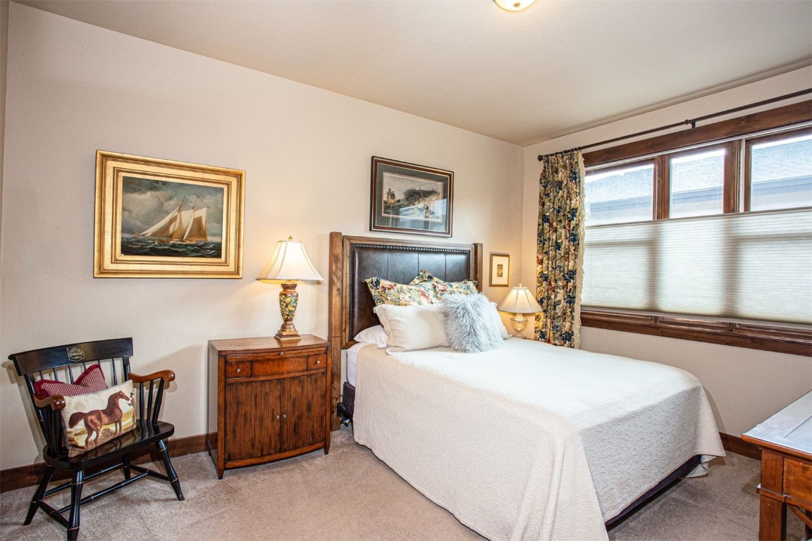 421 Rainbow Drive, Unit 5 Silverthorne, CO 80498 - Photo 19 of 36 a bedroom with a bed and a window with chair