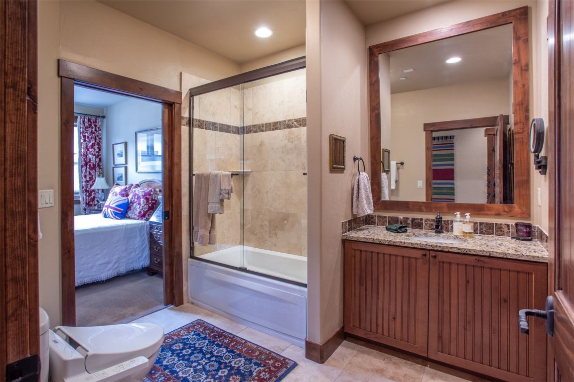 421 Rainbow Drive, Unit 5 Silverthorne, CO 80498 - Photo 27 of 36 a bathroom with a tub mirror and sink