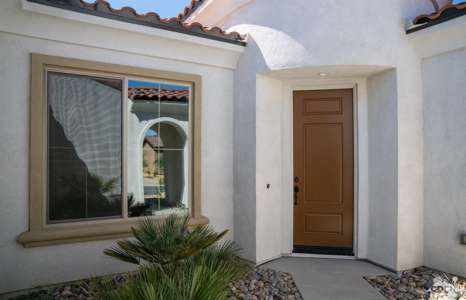 15 Riesling Rancho Mirage, CA 92270 - Photo 2 of 17 a glass door with a potted plant in front of a door