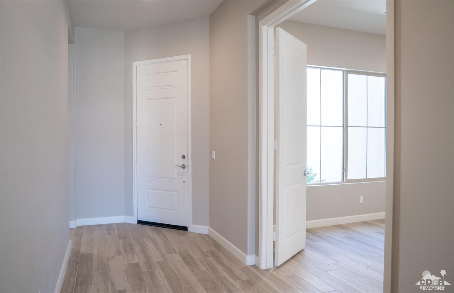 15 Riesling Rancho Mirage, CA 92270 - Photo 12 of 17 an empty room with wooden floor and windows