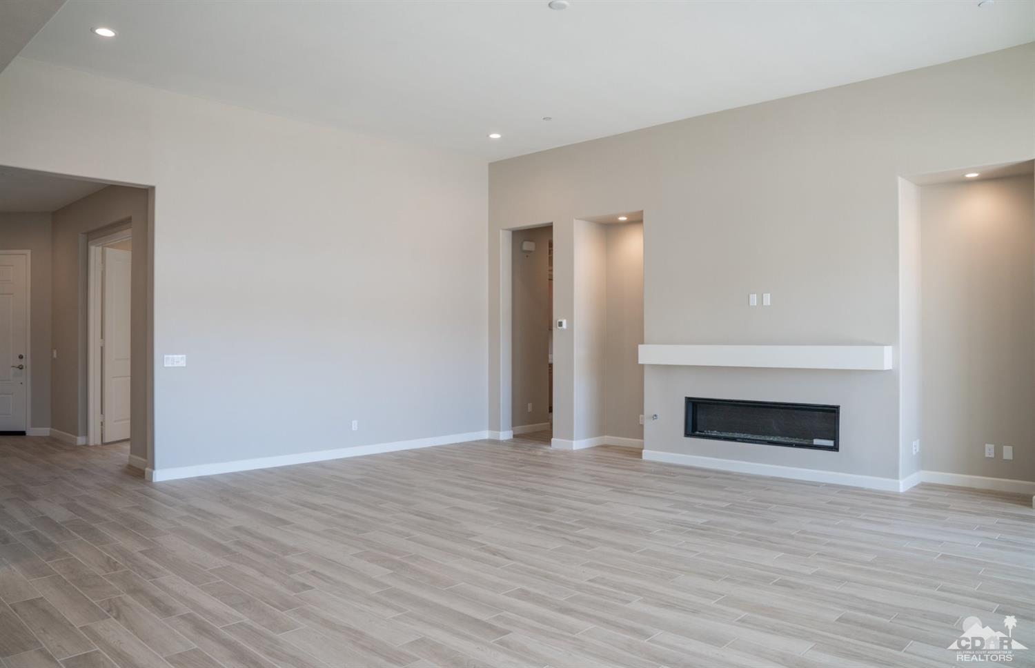 15 Riesling Rancho Mirage, CA 92270 - Photo 13 of 17 a view of an empty room with wooden floor fireplace and a window