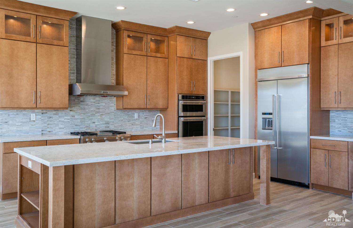 15 Riesling Rancho Mirage, CA 92270 - Photo 14 of 17 a kitchen with stainless steel appliances granite countertop a refrigerator a sink and wooden cabinets