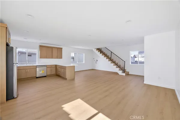 a view of empty room with wooden floor and stairs