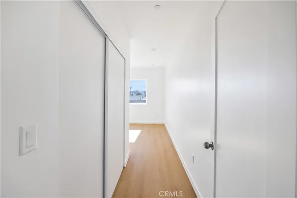 a view of a hallway with wooden floor and entryway