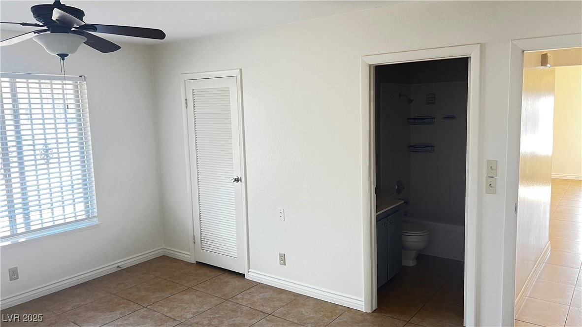 1486 Elizabeth Avenue, Unit 1 Las Vegas, NV 89119 - Photo 17 of 34 Unfurnished bedroom featuring multiple windows, light tile patterned flooring, and ceiling fan