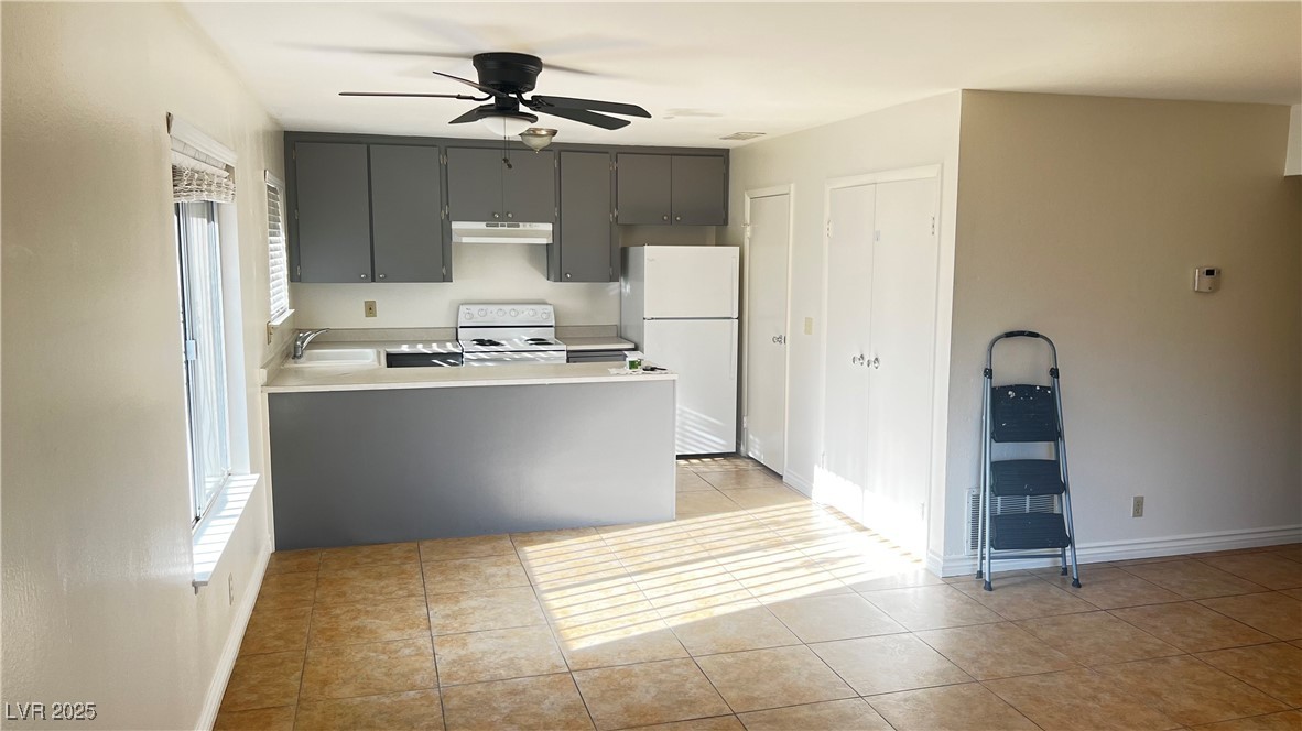 1486 Elizabeth Avenue, Unit 1 Las Vegas, NV 89119 - Photo 25 of 34 Kitchen with light tile patterned floors, white appliances, a peninsula, light countertops, and ceiling fan