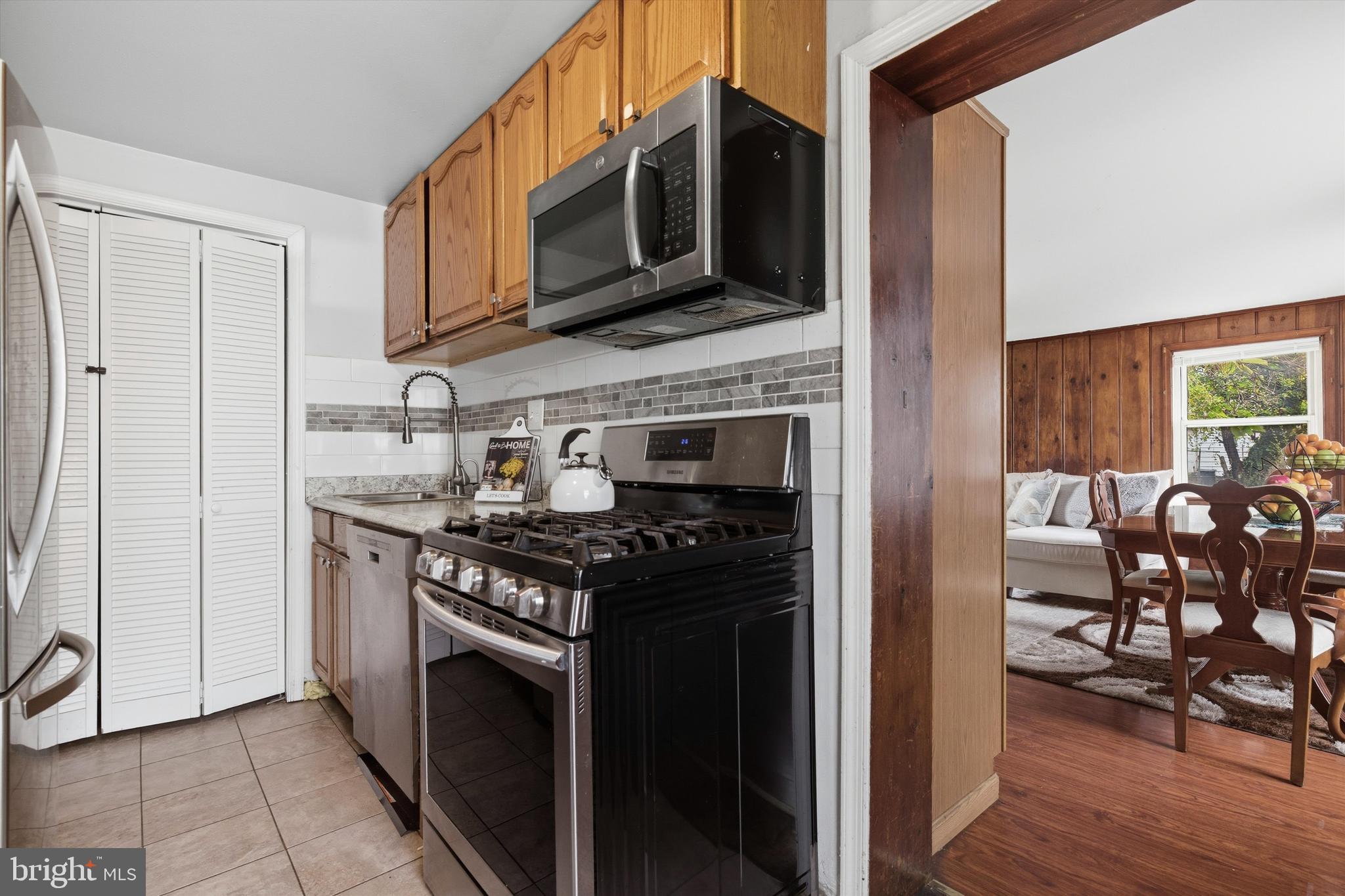 5024 Addison Road Capitol Heights, MD 20743 - Photo 9 of 23 a kitchen with stainless steel appliances granite countertop a stove top oven microwave and cabinets