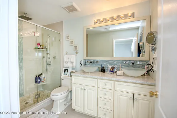a bathroom with a granite countertop sink a toilet and a mirror