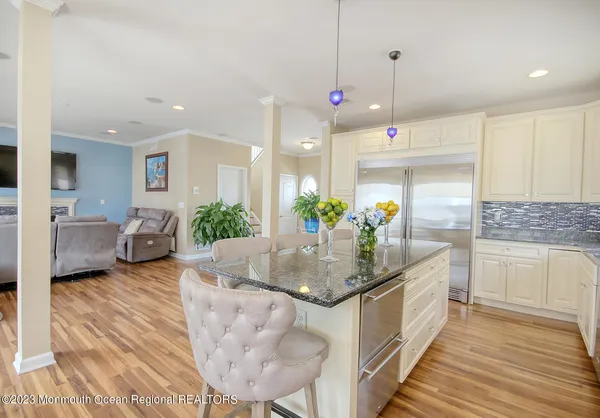 a kitchen with stainless steel appliances granite countertop a sink a stove and white cabinets