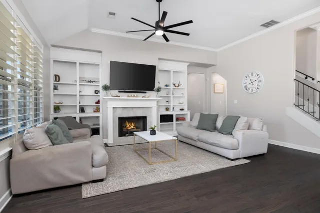 a living room with furniture a fireplace and a flat screen tv