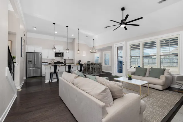 a living room with furniture and kitchen view