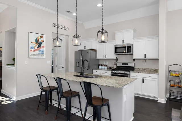 a kitchen with stainless steel appliances granite countertop a stove a refrigerator a kitchen island a sink and a refrigerator