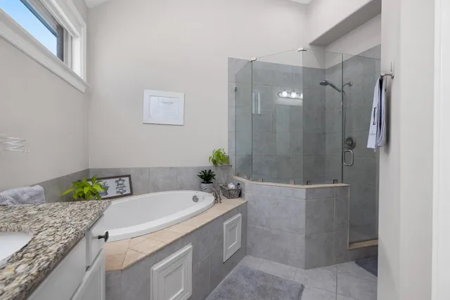 a bathroom with a granite countertop sink a toilet and shower