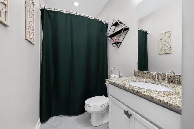 a bathroom with a granite countertop shower and a toilet