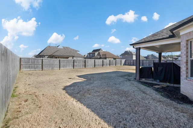 a view of a backyard with a garden and barbeque grill