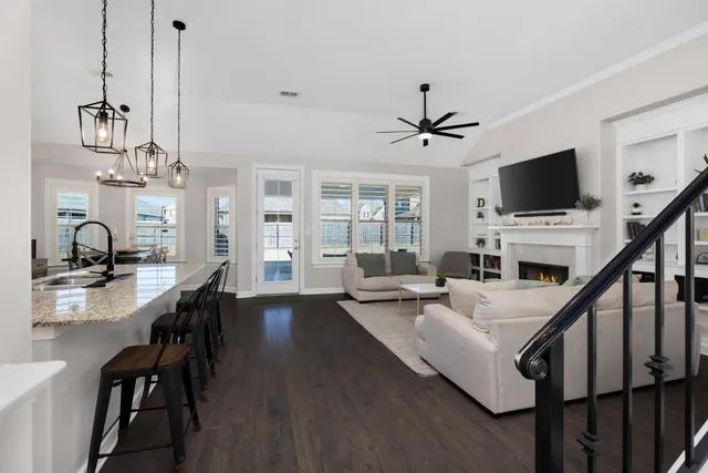 a living room with furniture flat screen tv and a ceiling fan
