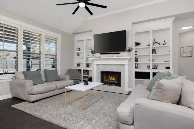 a living room with furniture a flat screen tv and a fireplace