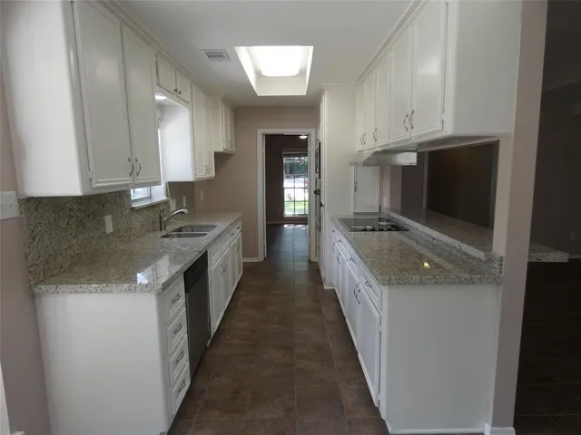 a kitchen with stainless steel appliances granite countertop a sink a stove and a refrigerator