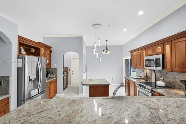 a kitchen with stainless steel appliances granite countertop a sink stove and refrigerator