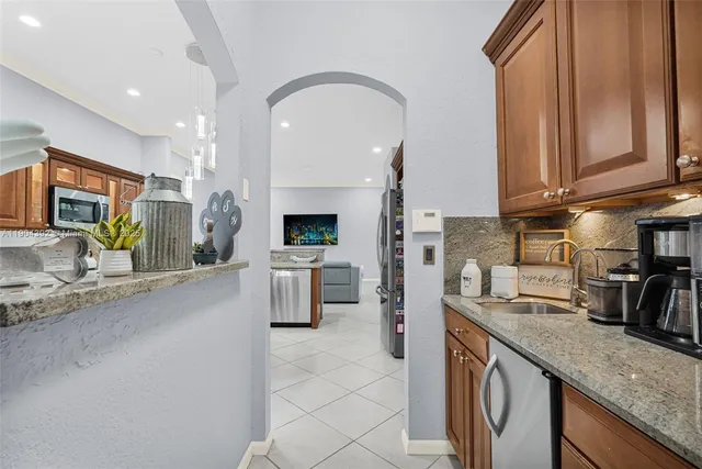 a kitchen with stainless steel appliances granite countertop a sink stove and refrigerator
