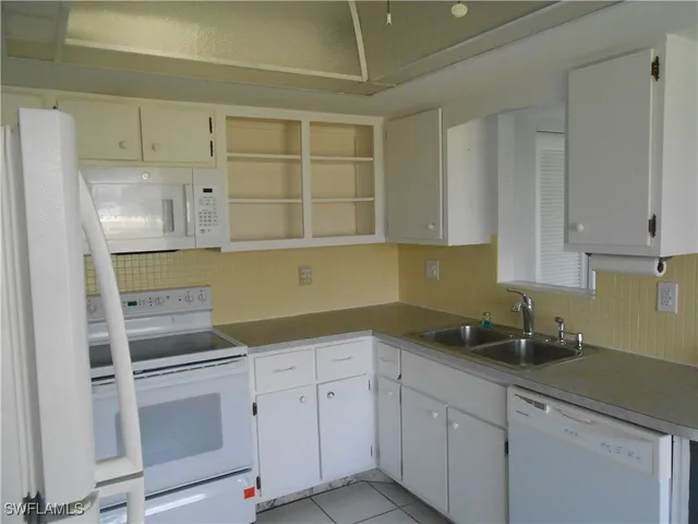 a kitchen with white cabinets and white appliances