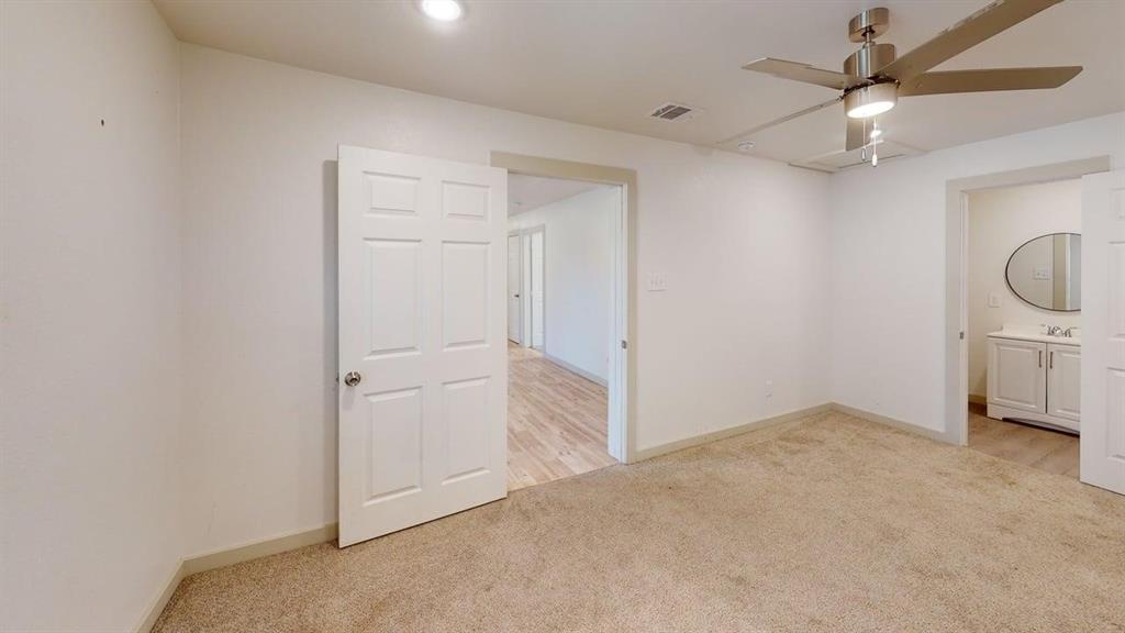 2554 Marfa Avenue Dallas, TX 75216 - Photo 11 of 19 Unfurnished bedroom with light carpet, ceiling fan, and connected bathroom