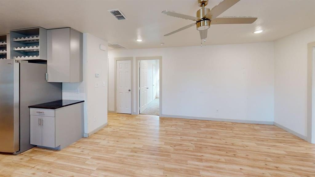 2554 Marfa Avenue Dallas, TX 75216 - Photo 10 of 19 Kitchen with dark countertops, freestanding refrigerator, light wood-style flooring, a ceiling fan, and open shelves