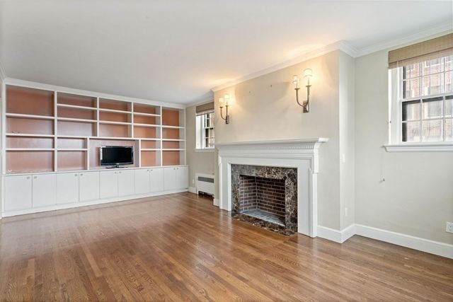 a living room with a fireplace and a floor to ceiling window