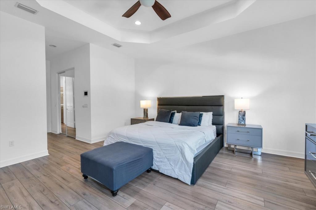 3376 Atlantic Circle Naples, FL 34119 - Photo 15 of 23 a spacious bedroom with a bed and wooden floor