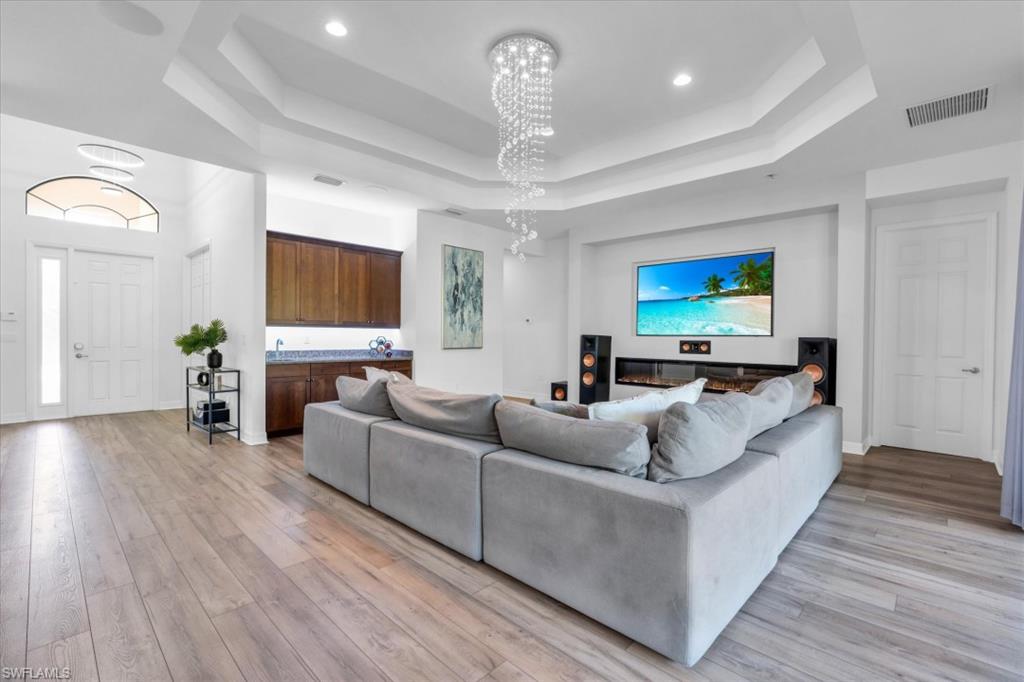 3376 Atlantic Circle Naples, FL 34119 - Photo 2 of 23 a living room with furniture and a flat screen tv