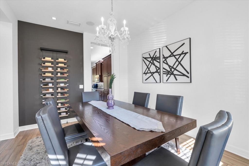 3376 Atlantic Circle Naples, FL 34119 - Photo 8 of 23 a living room with furniture a chandelier and a dining table