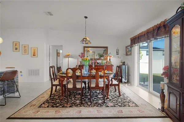 a view of a dining room and livingroom with furniture wooden floor a rug a rug a rug and a chandelier
