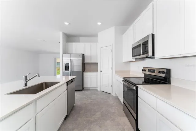 a kitchen with white cabinets and stainless steel appliances