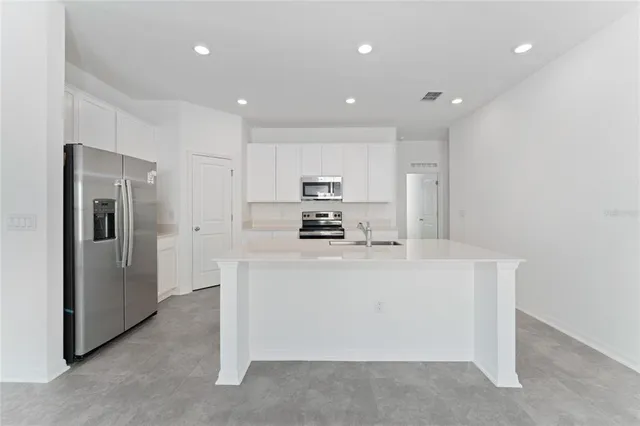 a kitchen with stainless steel appliances a refrigerator sink and microwave