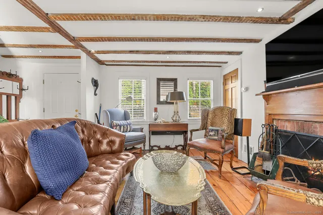 a living room with furniture a flat screen tv and a window