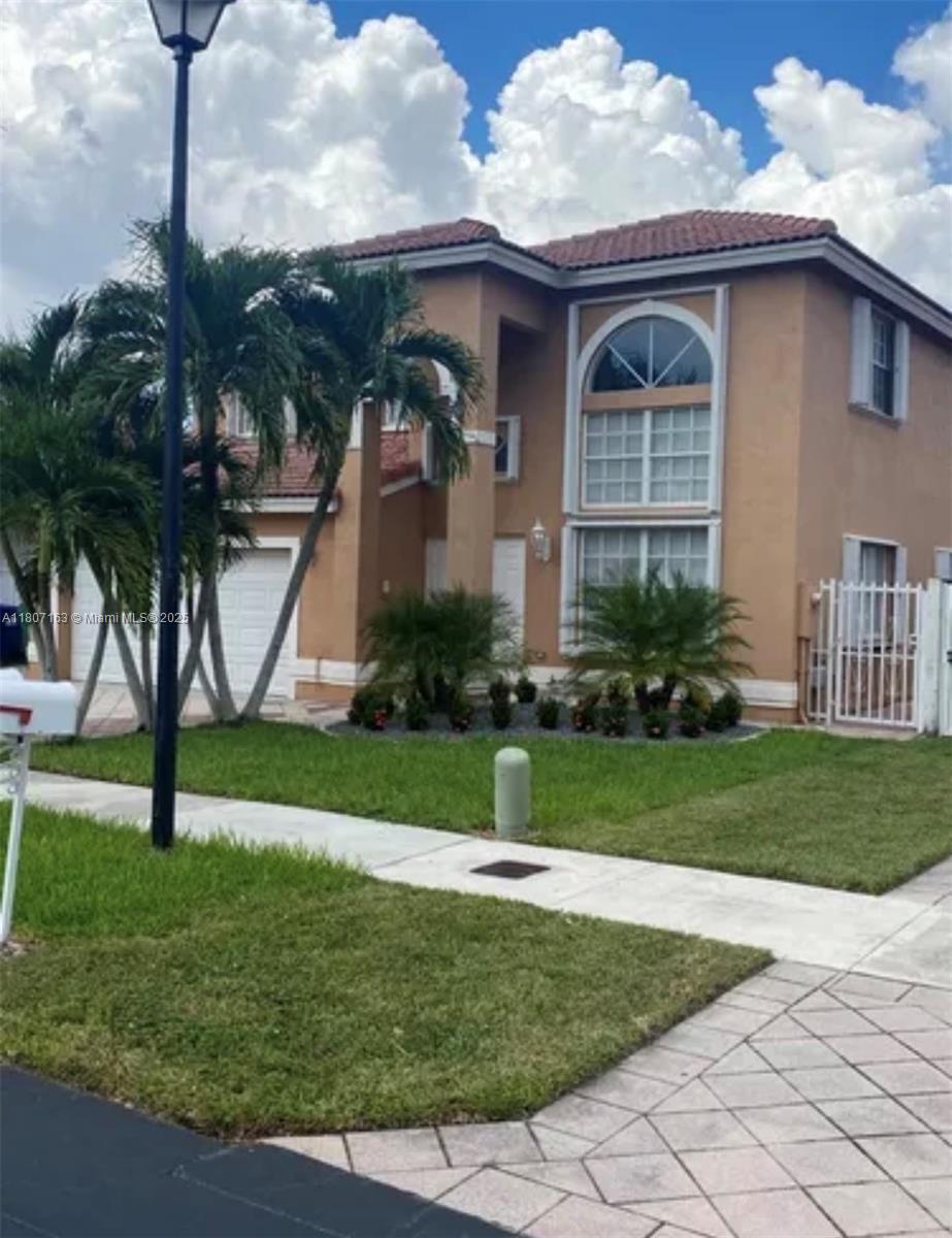 16461 Southwest 100th Terrace Miami, FL 33196 - Photo 1 of 18 a front view of a house with garden