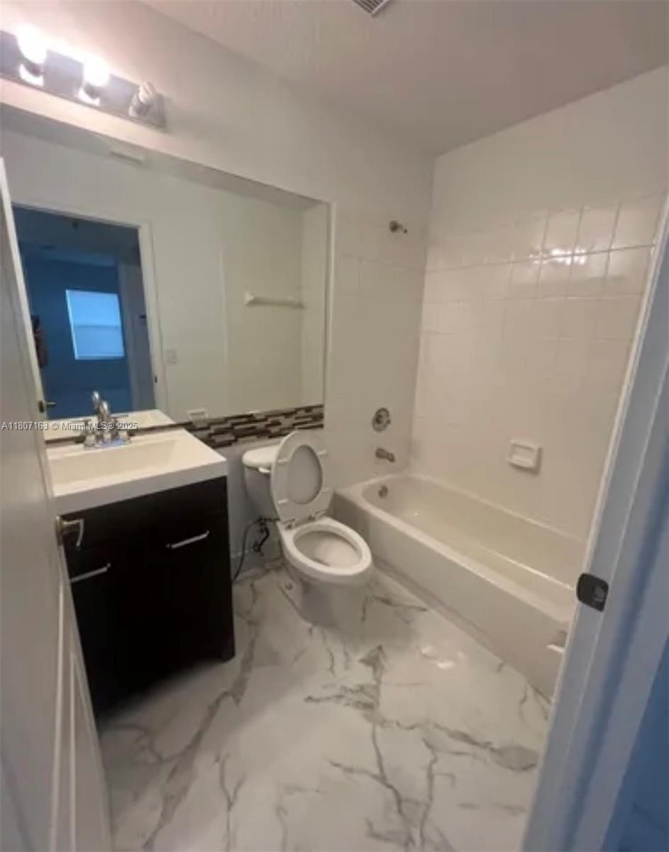 16461 Southwest 100th Terrace Miami, FL 33196 - Photo 12 of 18 a bathroom with a sink a toilet a mirror and bathtub