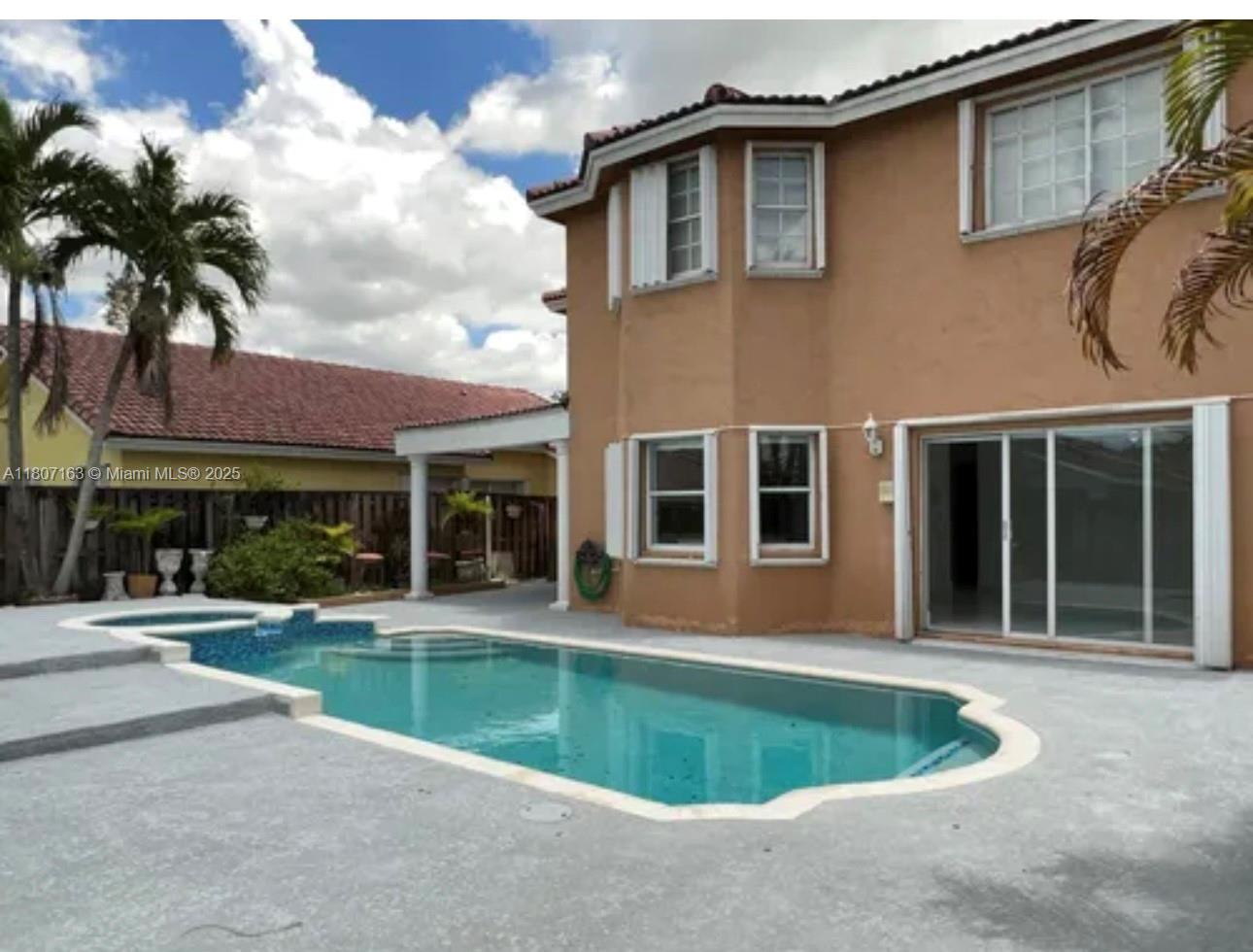 16461 Southwest 100th Terrace Miami, FL 33196 - Photo 15 of 18 a front view of a house with swimming pool and glass windows