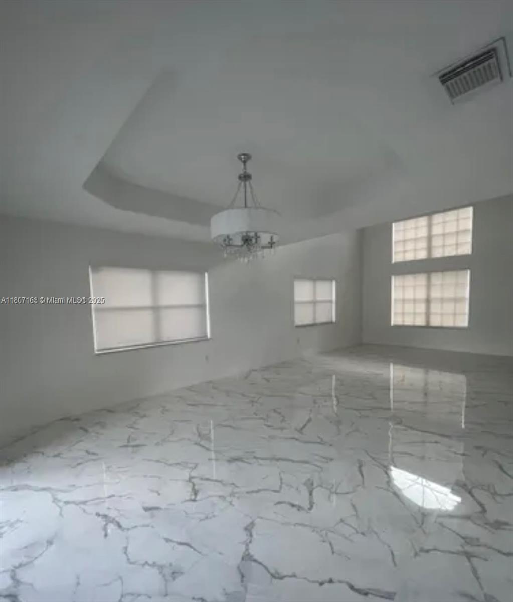 16461 Southwest 100th Terrace Miami, FL 33196 - Photo 4 of 18 an empty room with windows and fireplace