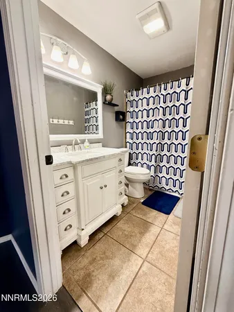 a bathroom with a sink a toilet a mirror and shower