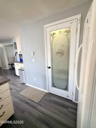 a view of a hallway with wooden floor and door