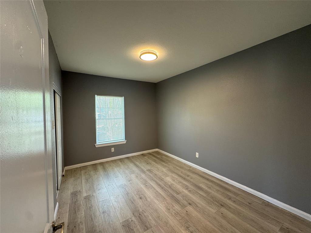 7315 Toland Street Dallas, TX 75227 - Photo 12 of 16 an empty room with wooden floor and windows