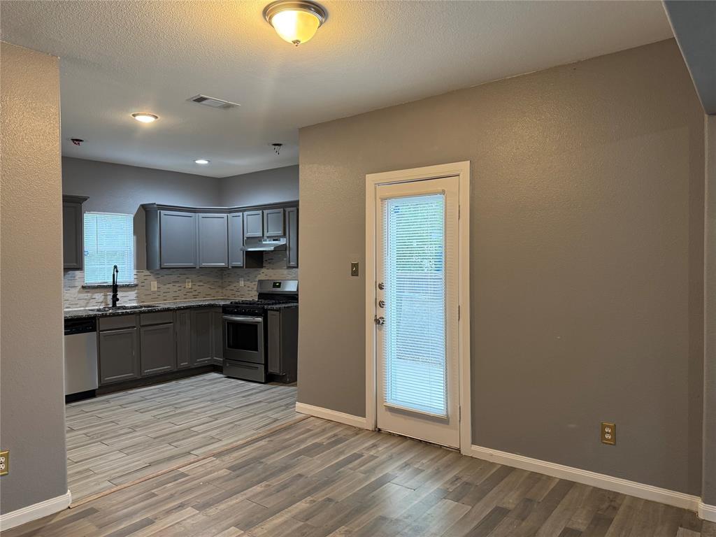 7315 Toland Street Dallas, TX 75227 - Photo 4 of 16 a large kitchen with a refrigerator and a stove top oven