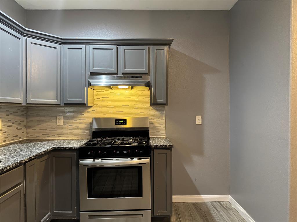 7315 Toland Street Dallas, TX 75227 - Photo 6 of 16 a kitchen with granite countertop a stove and a sink