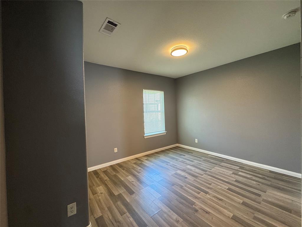 7315 Toland Street Dallas, TX 75227 - Photo 10 of 16 an empty room with wooden floor and windows
