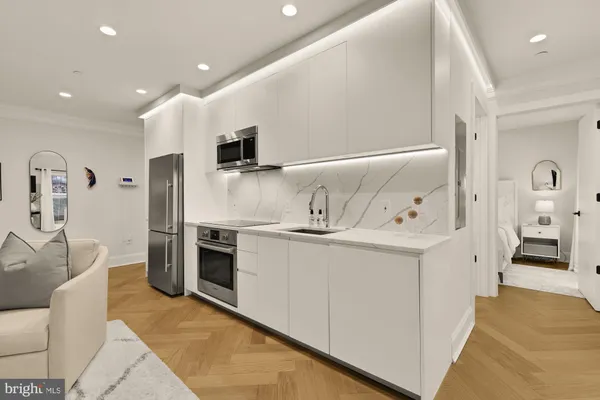 a kitchen with stainless steel appliances kitchen island granite countertop a refrigerator and a sink