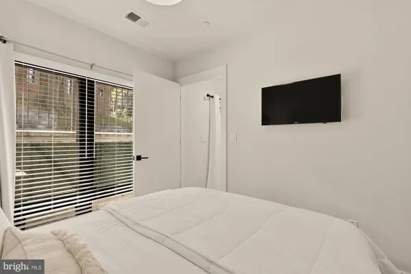 a bedroom with a bed and a flat screen tv