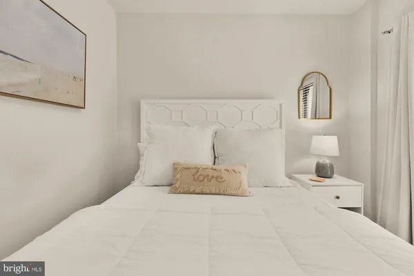 a bedroom with a bed and a lamp on dresser